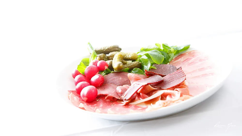 Assiette de charcuterie, viande séchée, jambon cru, cornichons et radis