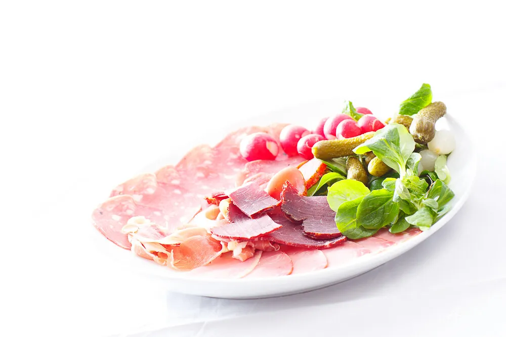 Assiette de charcuterie franc-comtoise, mâche, radis et cornichons