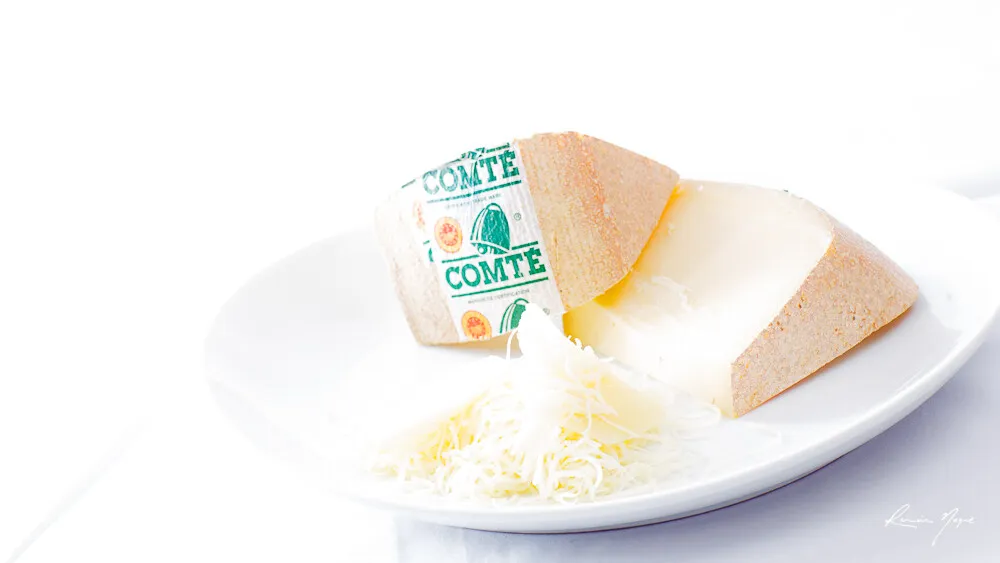 Quartiers de Comté et fromage râpé sur une assiette