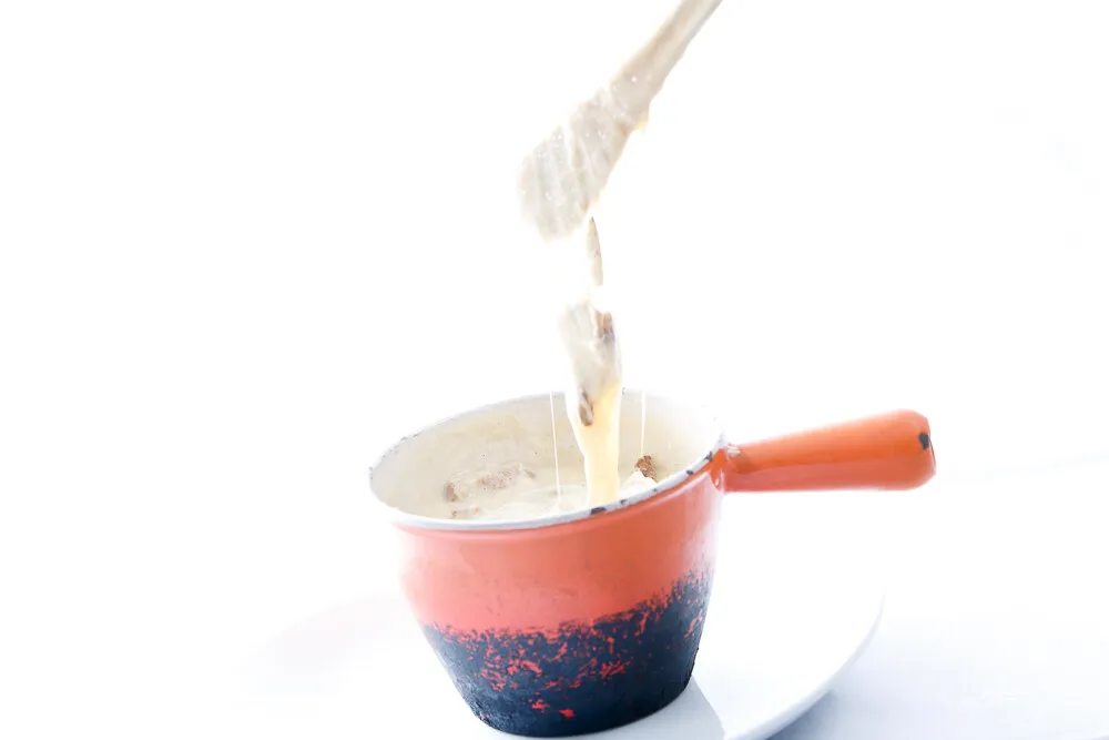 La fondue file de la fourchette au-dessus du caquelon
